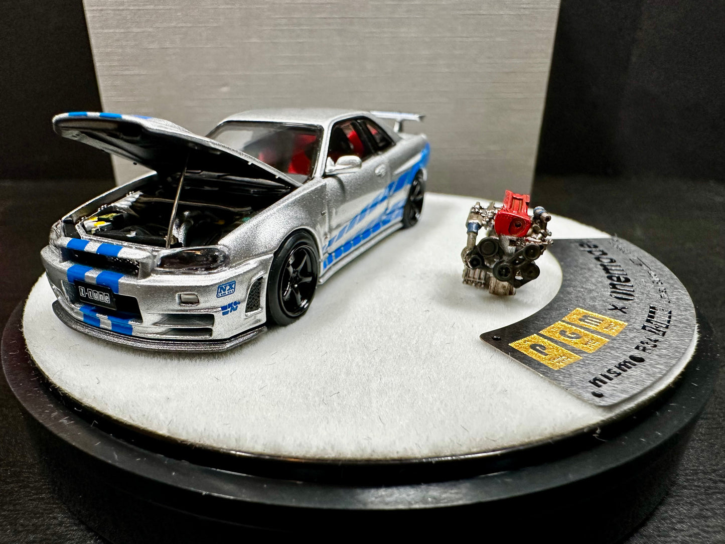 x One Model 1/64 Nissan Skyline GT-R R34 Z-Tune Silver w/ Blue Strip Luxury Round Stand Ver(1 pc)